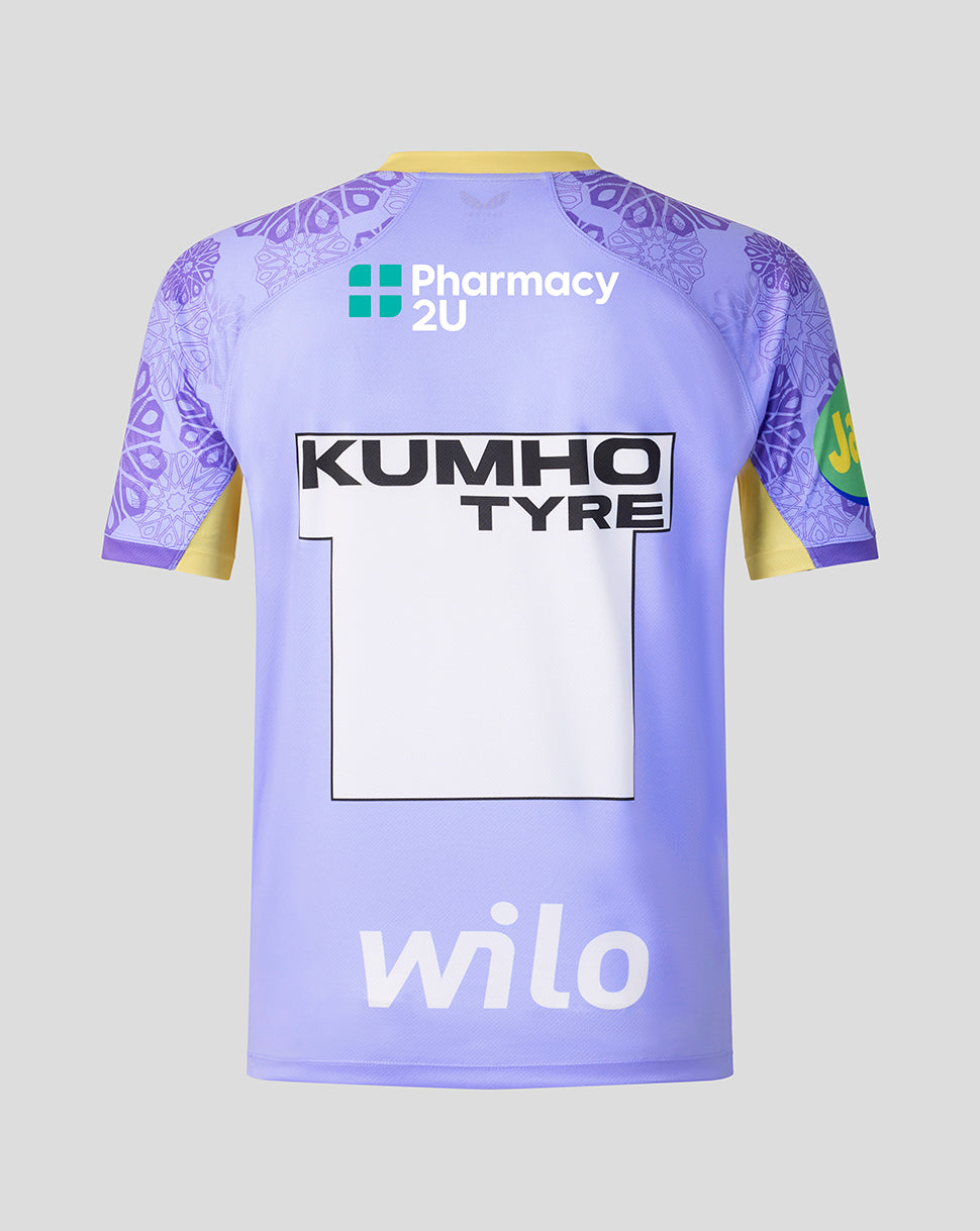 A light purple and lavender soccer jersey shown from the back, featuring 'KUMHO TYRE' and 'Pharmacy 2U' sponsor logos, the number '1' on the back, and 'wilo' at the bottom. The jersey has yellow sleeve accents and purple patterned shoulder panels, set against a solid light gray background.