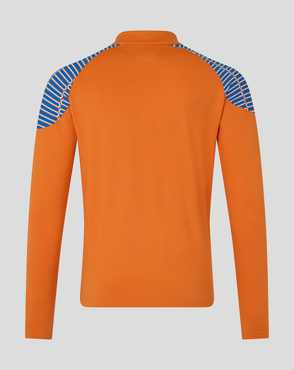An orange long-sleeve athletic top shown from the back, featuring blue and white diagonal striped panels on the shoulders, set against a solid gray background.