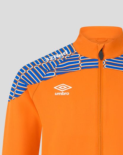 Close-up of an orange zip-up athletic jacket with blue and white patterned shoulder panels and a white Umbro logo on the chest, shown against a light gray background.