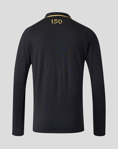 A long-sleeve black polo shirt shown from the back, featuring a gold '150' print on the collar and subtle tonal wave patterns across the back, set against a solid light gray background.