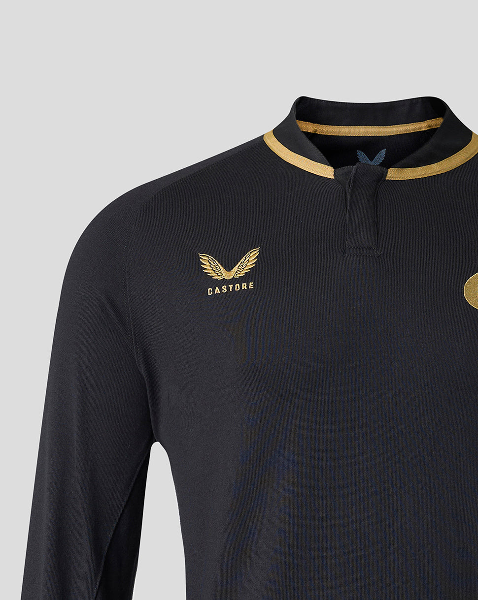 Close-up of a dark navy long-sleeve athletic jersey with gold trim around the collar, featuring the Castore wing logo on the chest.