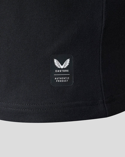 Close-up of a black ribbed knit garment showing a small rectangular Castore patch with a winged logo and the words 'AUTHENTIC PRODUCT' on a light gray background.