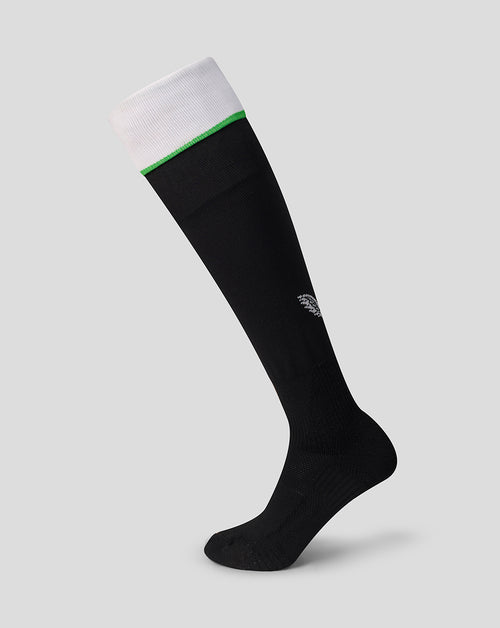 Black knee high sock with white cuff, green stripe, and a small logo on the calf