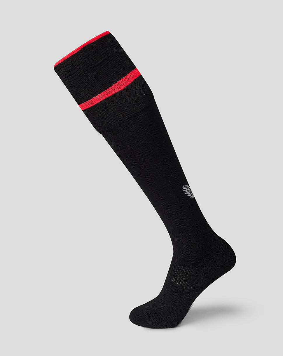 A single black knee-high athletic sock with a red band near the cuff and a small white logo on the lower leg, shown on a light gray background.
