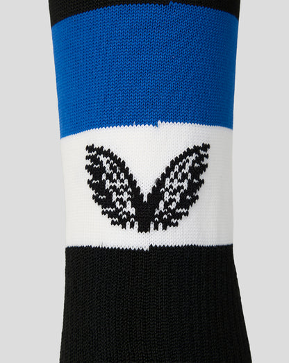 A close-up of a knit crew sock featuring horizontal stripes of black, blue, and white, with a black castore logo knitted across the white band