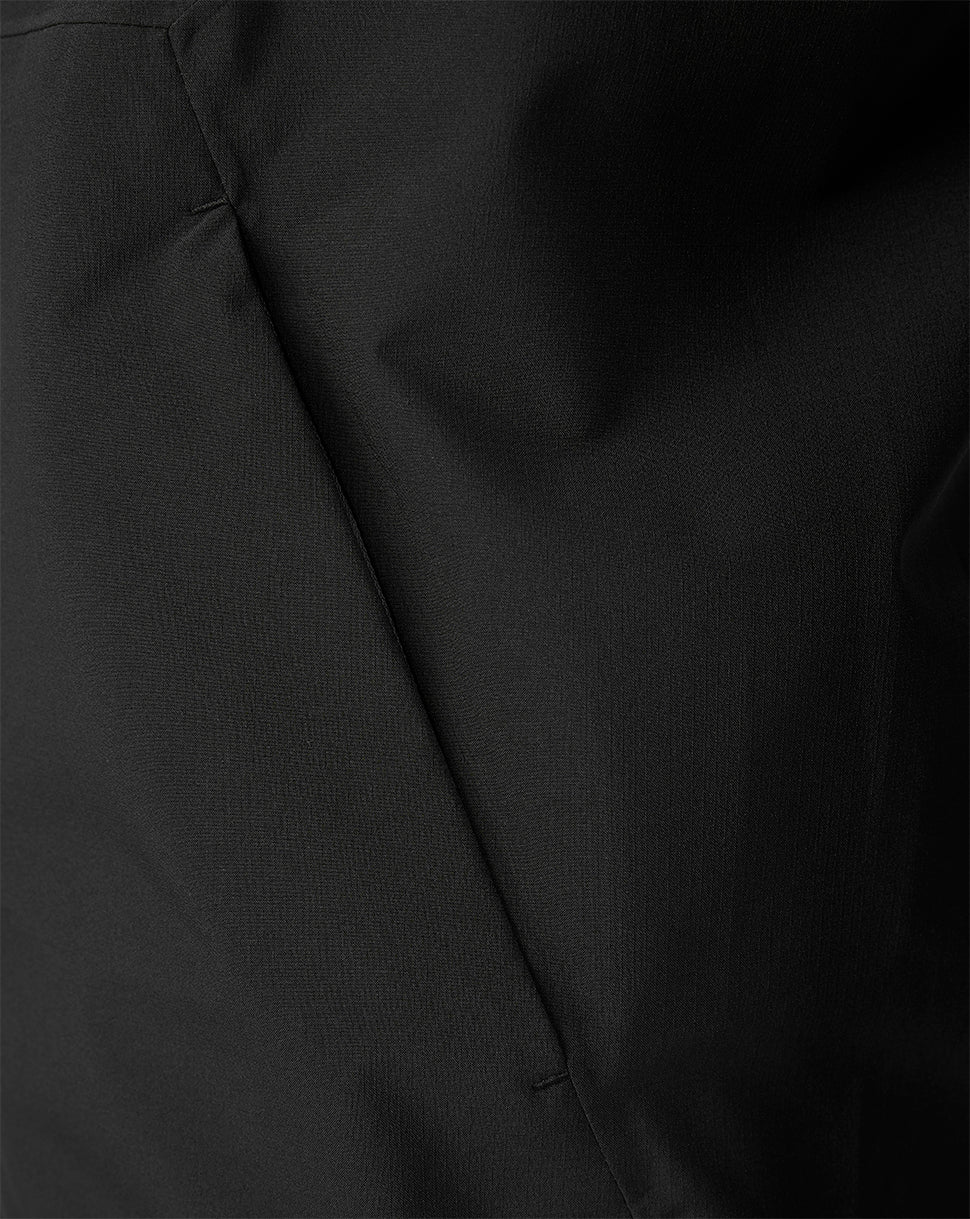 Close-up of a black fabric surface with a visible seam and soft folds.