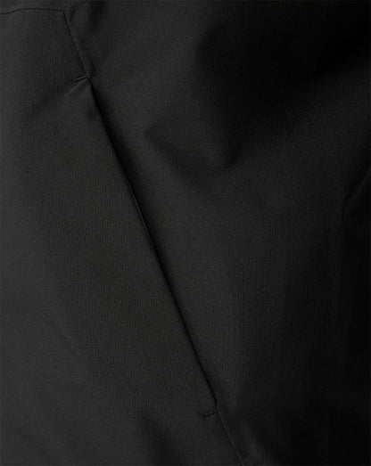 Close-up of a black fabric surface with a visible seam and soft folds.