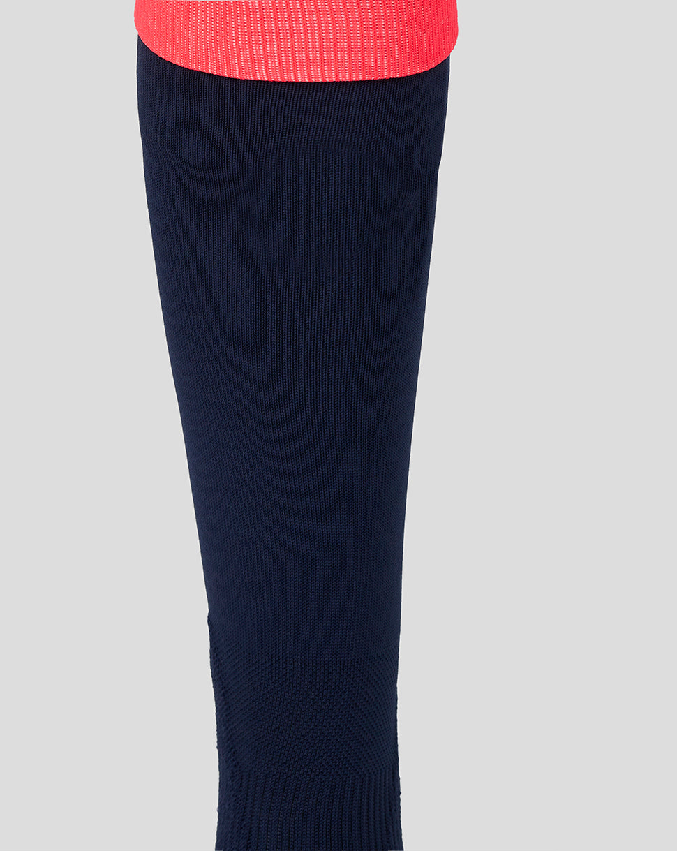 Lower leg view of navy sock with pink cuff and light gray heel and toe and striped midfoot panel.