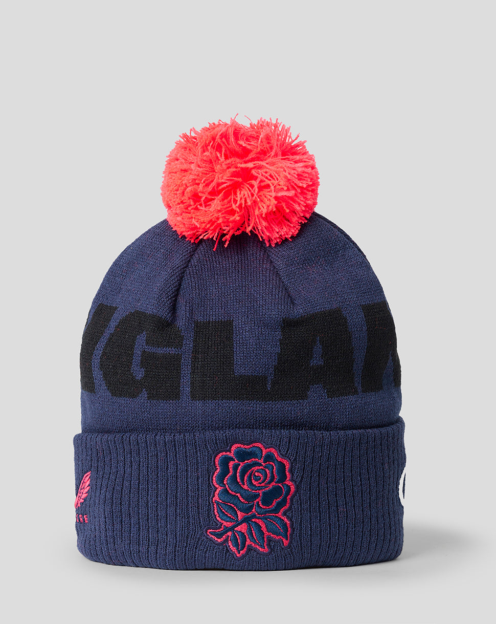 Navy blue beanie with red pom-pom and rose embroidery on a light gray background