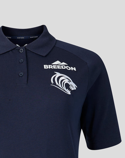 Left chest shows white Castore emblem and club crest on navy Travel Polo.