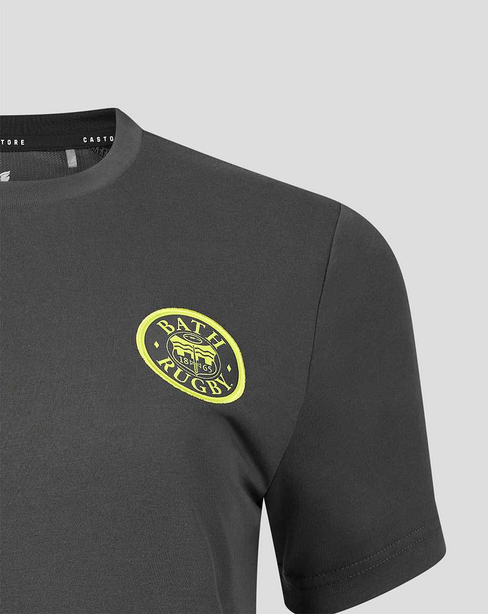 Close-up of a dark gray short-sleeve t-shirt featuring a yellow and black oval 'BATH RUGBY' logo on the left chest, set against a light gray background.
