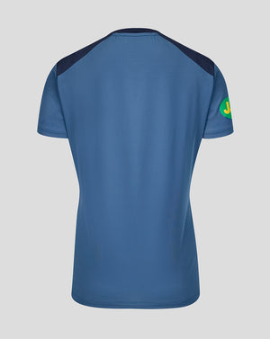 Back view of blue training T-Shirt showing dark shoulder panels and a green circular sleeve patch.