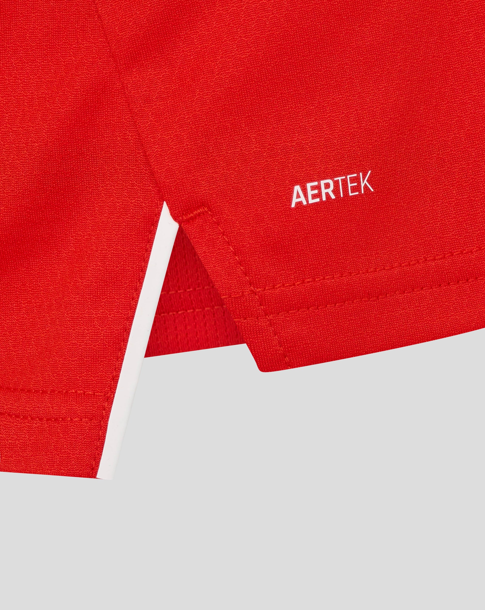 Close-up of red England women's T20 Pro shirt fabric with stitching and AERTEK branding