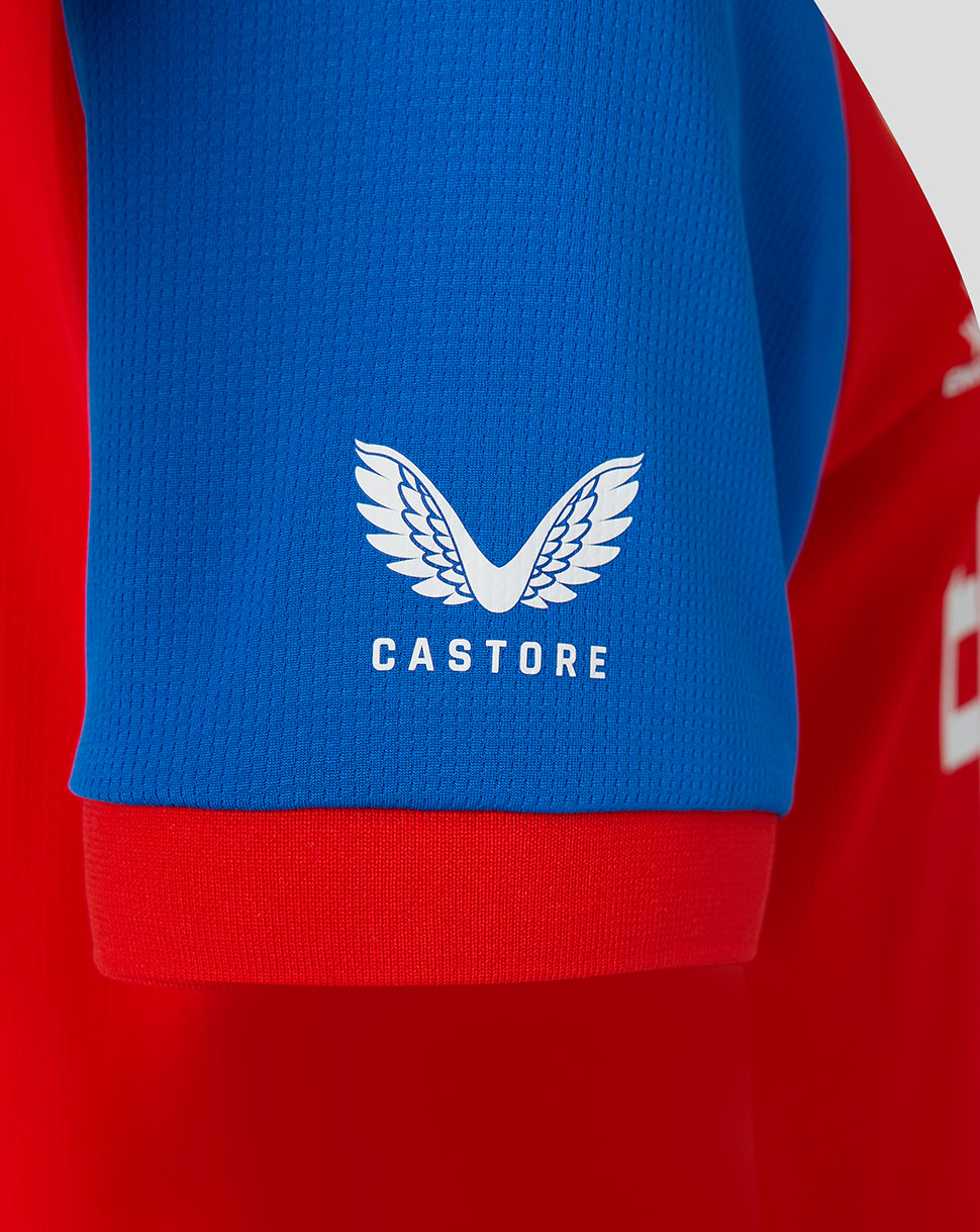 Red sports jersey with blue sleeve featuring Castore logo