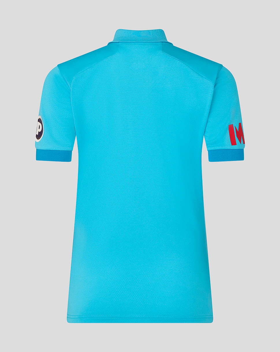 Blue polo shirt with brand logos on sleeves against a light gray background