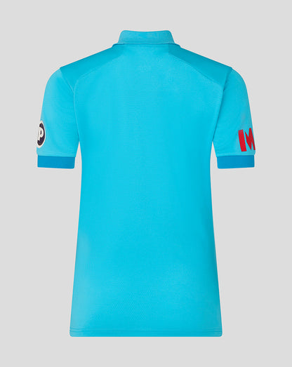 Blue polo shirt with brand logos on sleeves against a light gray background