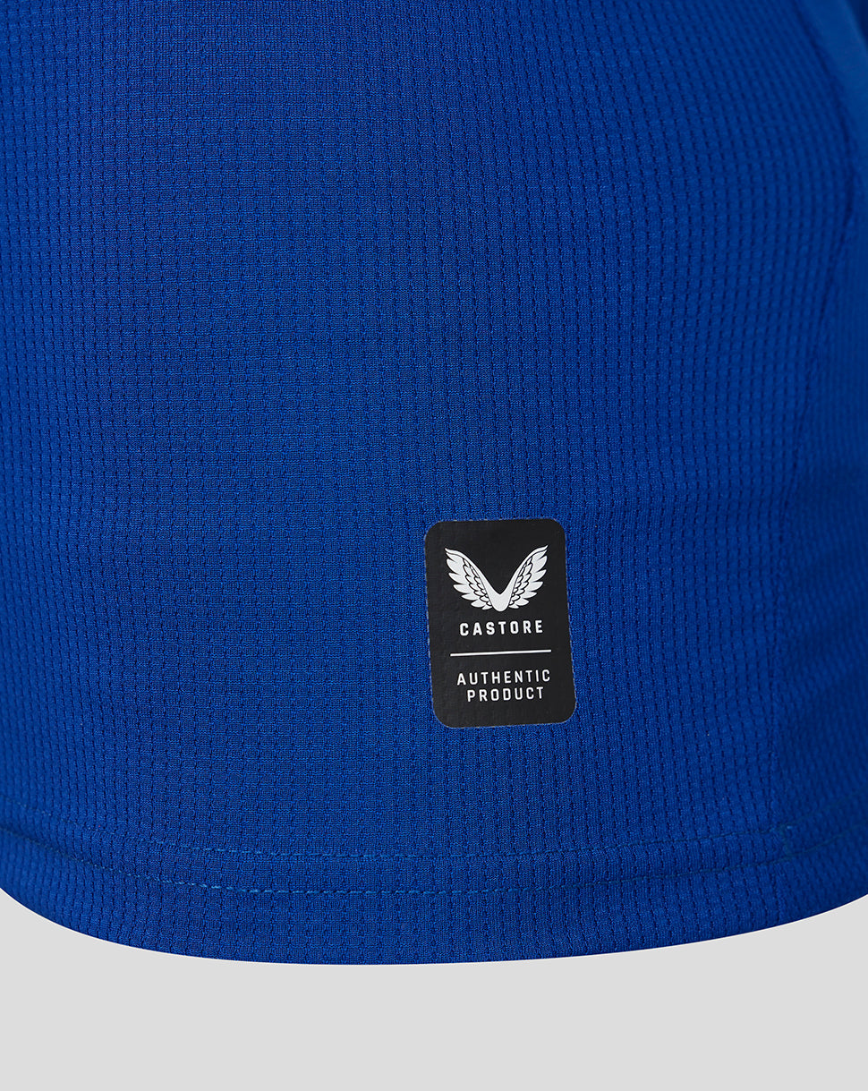 Blue textured fabric with a black label featuring a logo and text.