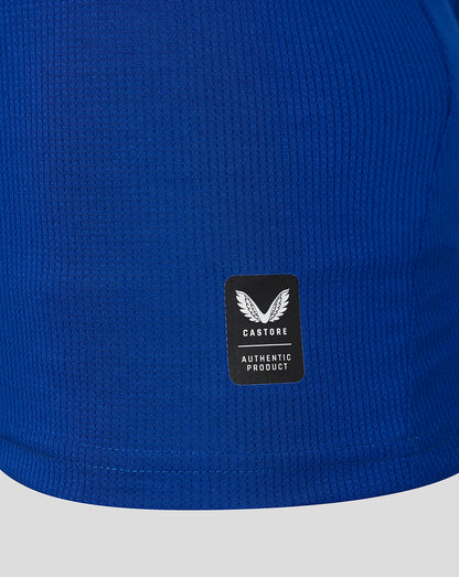 Blue textured fabric with a black label featuring a logo and text.