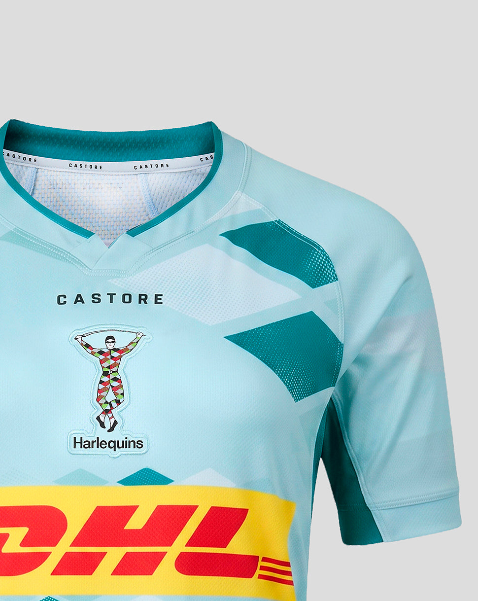A close-up of a light blue and teal soccer jersey with a yellow DHL sponsor stripe across the bottom and a Harlequins team crest on the chest.