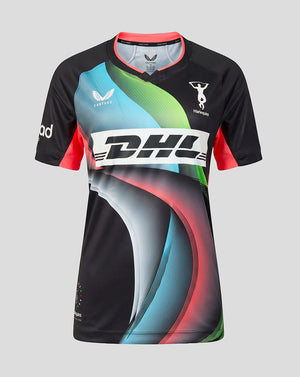 A short-sleeve athletic jersey with a black base and a vibrant abstract graphic in light blue, green, red, and gray. The jersey features a large white 'DHL' logo across the chest, a white 'Velozi' wing logo on the right chest, and a white 'Harlequins' logo on the left chest, set against a solid gray background.