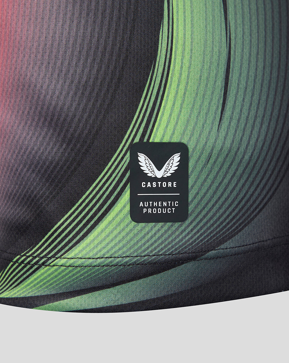 Close-up of athletic shirt showing a black Castore Authentic Product label sewn onto a dark gray and green wavy patterned fabric.