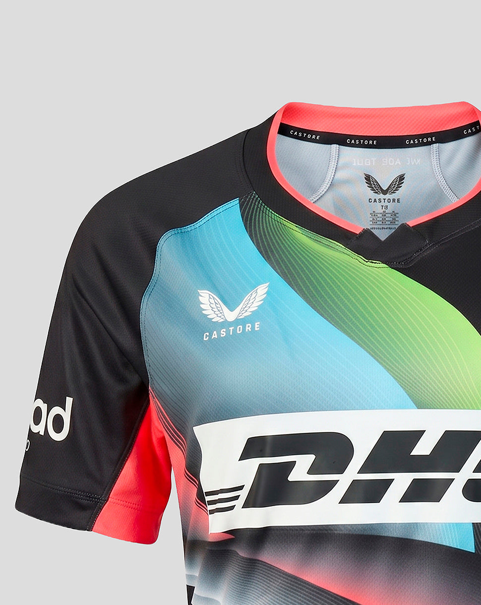 A close-up of a Castore athletic jersey with a black base, featuring a vibrant gradient of blue, green, and yellow on the chest, red side panels, and a large white DHL logo across the front.