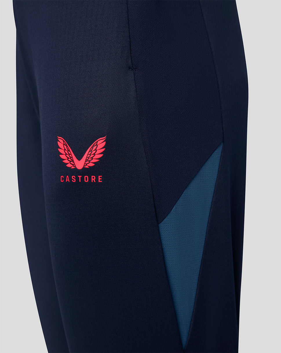 Navy training pants close up with pink Castore logo and teal panel