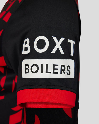 Close-up of a black and red patterned sports jersey sleeve featuring a white rectangular patch with the text 'BOXT BOILERS' in black lettering.