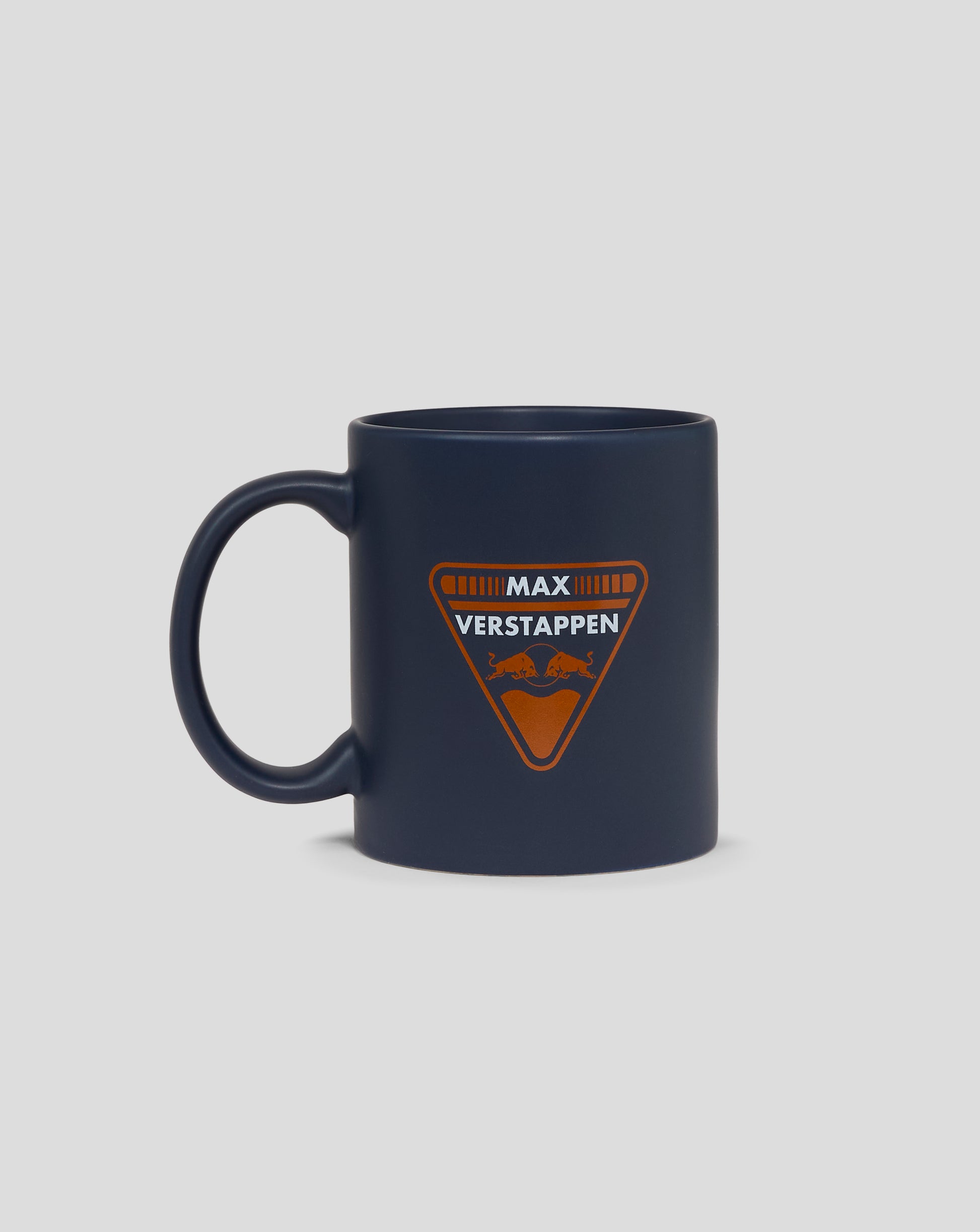 Dark blue mug featuring the orange Max Verstappen Red Bull Racing crest on the front with a handle on the left.