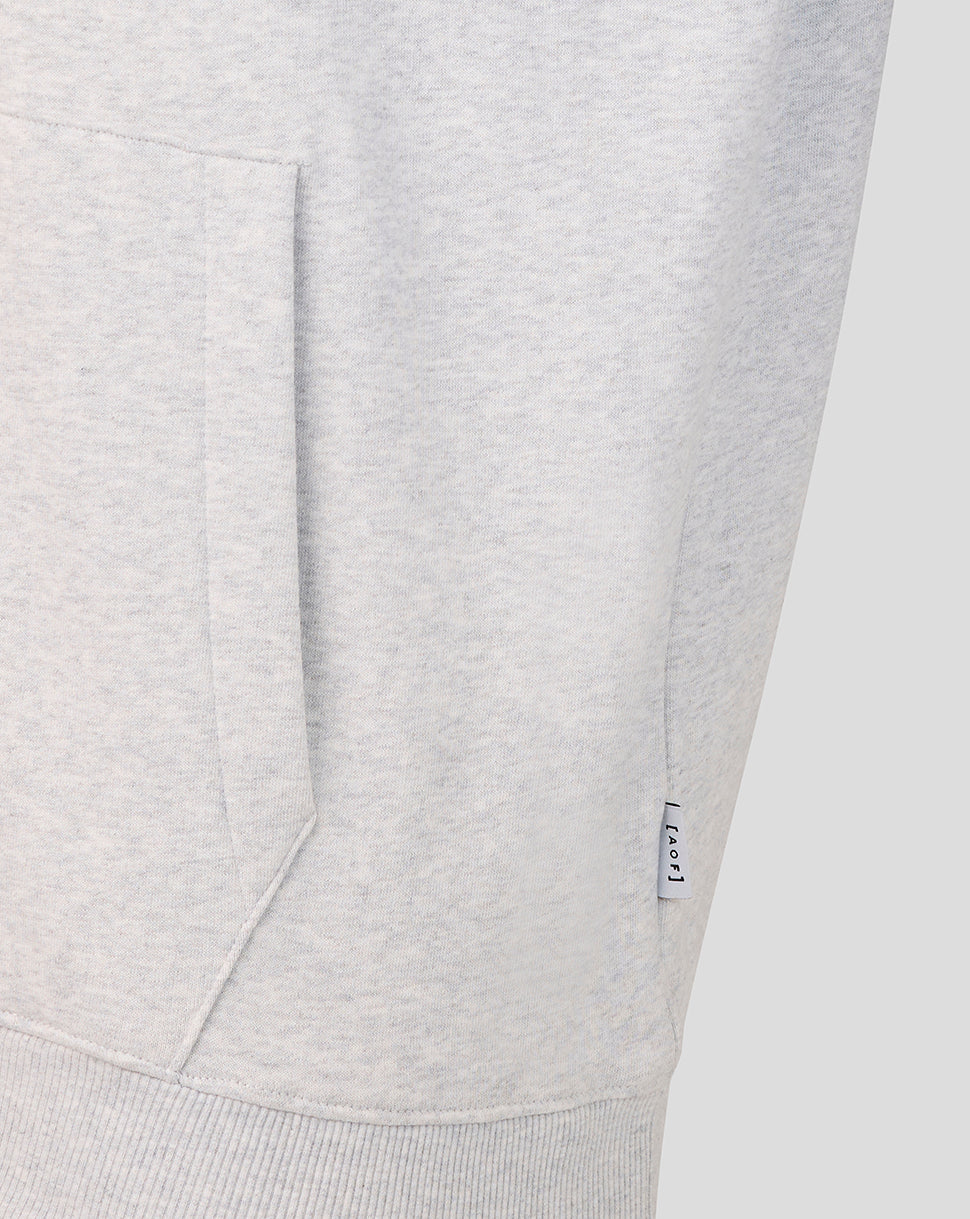 Close-up of the grey hoodie pocket with a small AOF tag along the side seam.