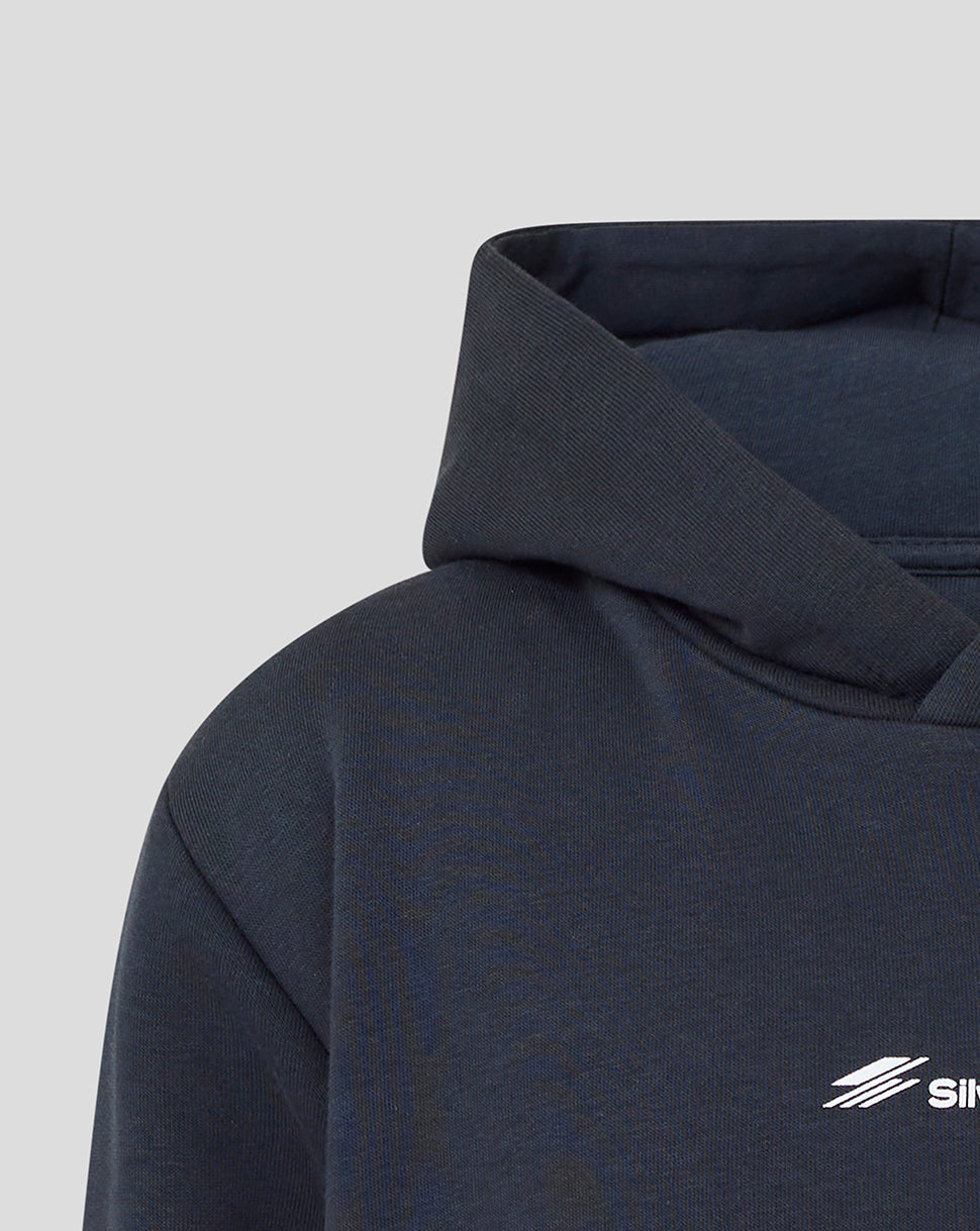 Close-up of a dark navy pullover hoodie showing the hood, shoulder, and a small white stylized logo on the chest against a light gray background.