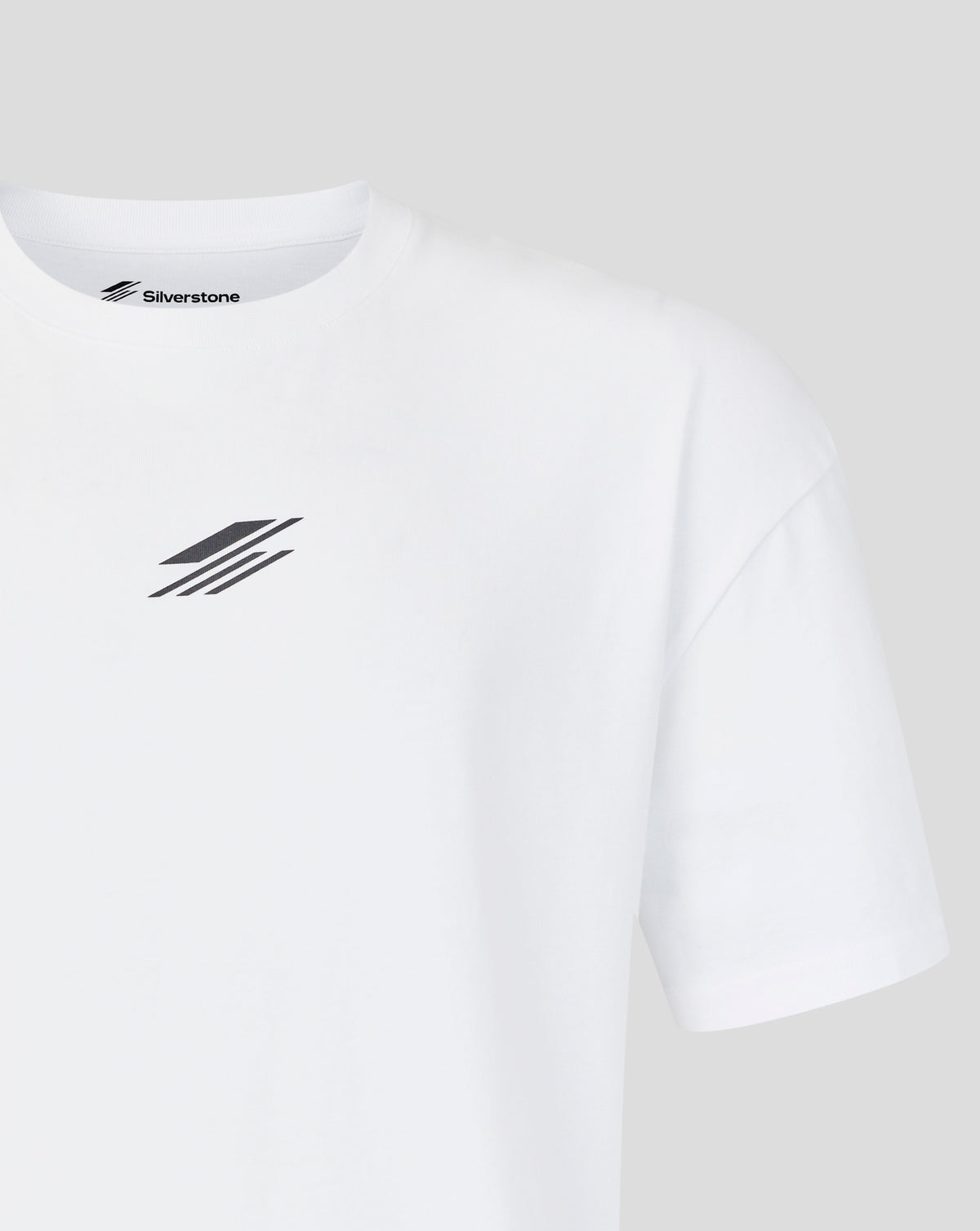 A close-up of a white short-sleeve crewneck t-shirt by Silverstone, featuring a black diagonal logo graphic on the left chest and the brand name printed inside the collar.