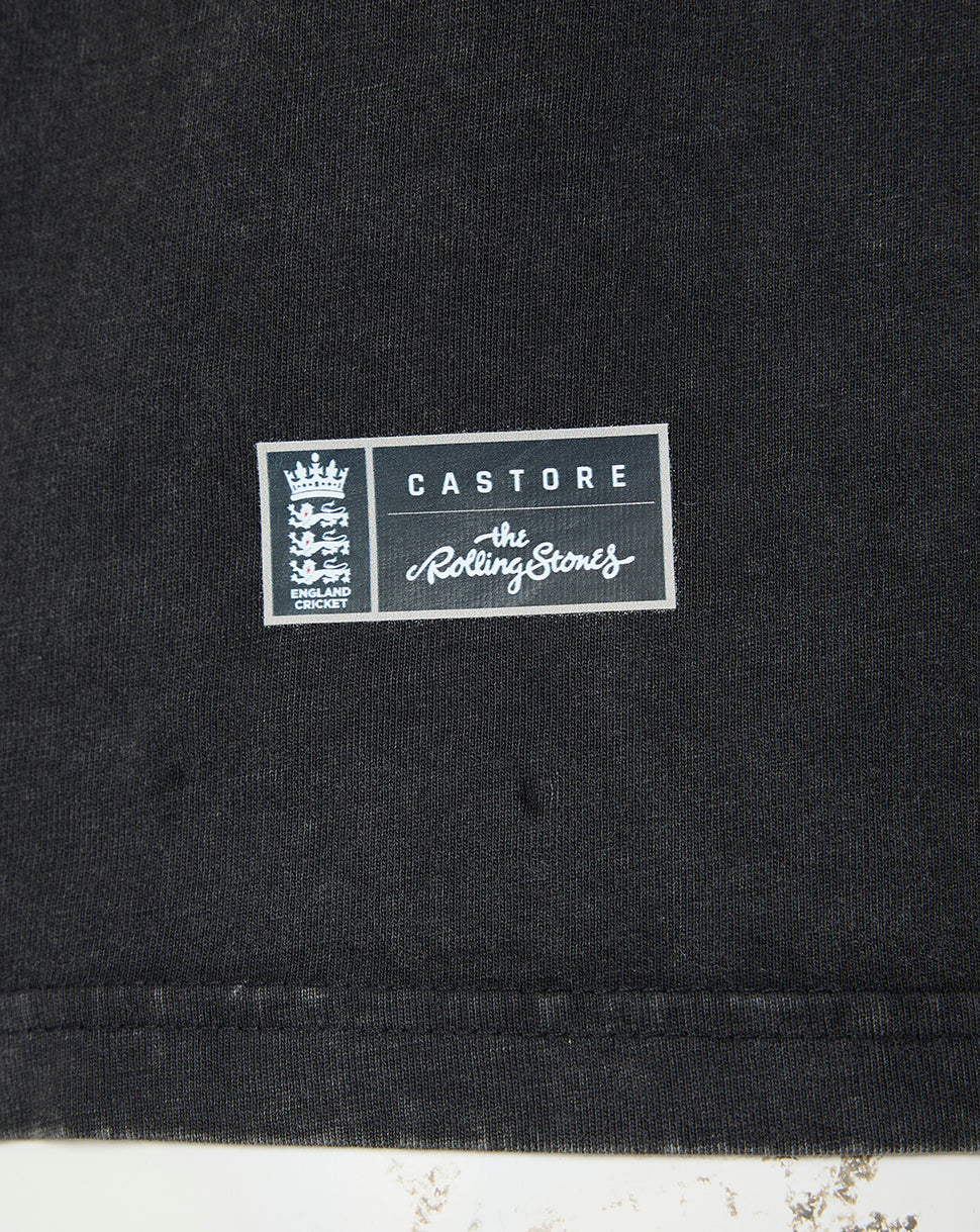 Close-up of a black fabric garment with a rectangular white and gray printed patch reading 'CASTORE' and 'The Rolling Stones' with the band's crest on the left.