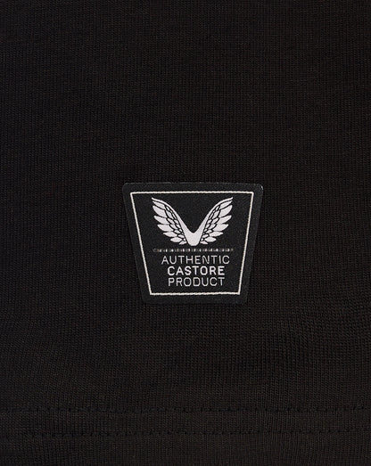 Close-up of a black knit fabric with a square authentic Castore product patch featuring wings.