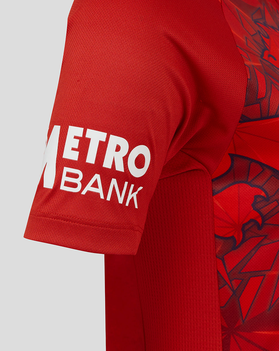 Close up of the sleeve showing METRO BANK branding in white on red fabric