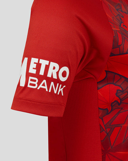 Close up of the sleeve showing METRO BANK branding in white on red fabric