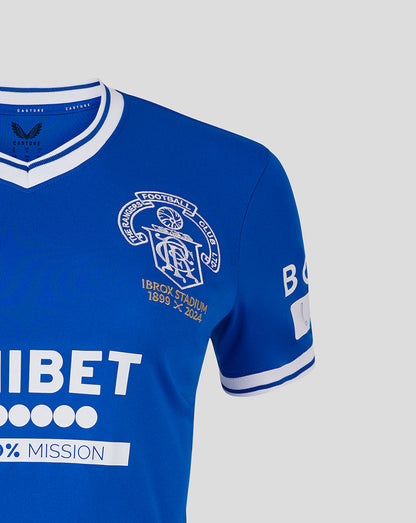 Close-up of blue Rangers shirt showcasing embroidered crest and gold Ibrox Stadium 1899 2024 text