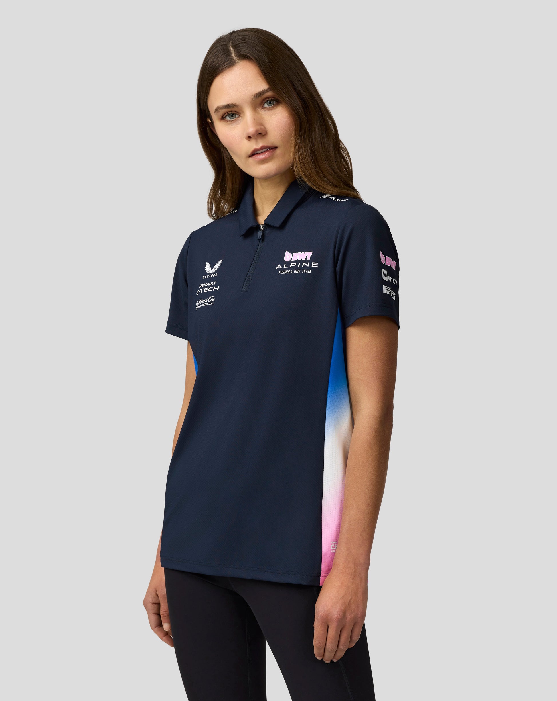 Female model wearing navy BWT Alpine Formula One Team polo with center front zip and team logos on the chest