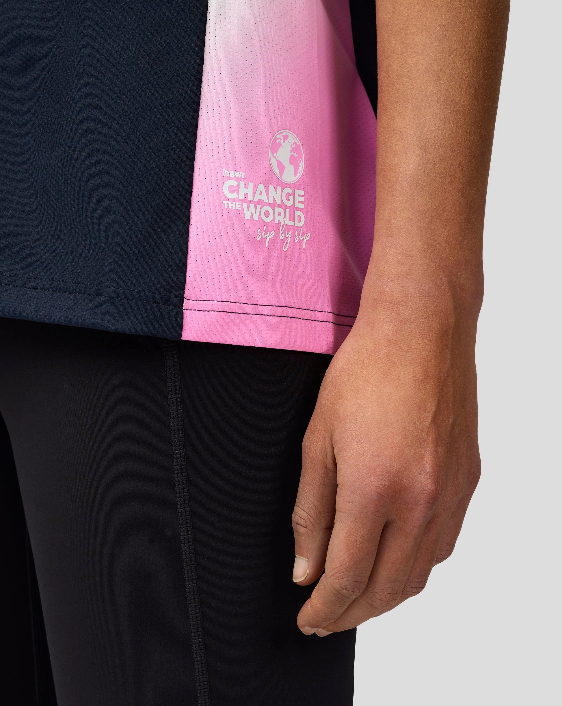 Close up of navy BWT Alpine women's T shirt with a pink side panel and sponsor branding including a world map logo