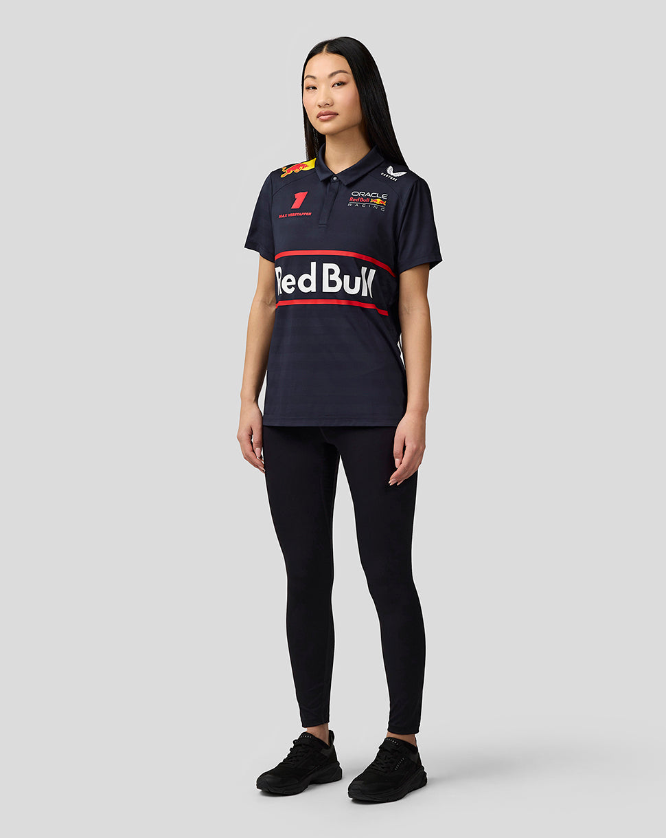 Full body shot of woman in navy night sky teamline polo with Red Bull branding, paired with black leggings and sneakers