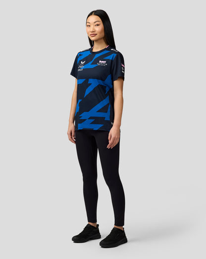 Front view of a woman wearing the navy BWT Alpine Pierre Gasly driver jersey with blue geometric pattern and sponsor logos.