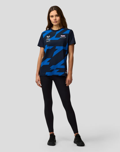 Front three-quarter view of a woman in navy Alpine F1 Team Jack Doohan jersey with blue geometric pattern and sponsor logos