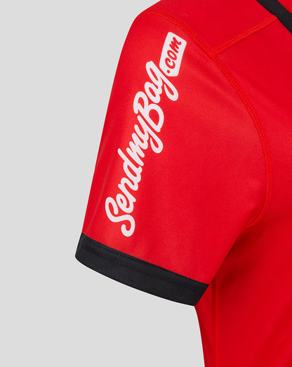 Close-up of red jersey sleeve showing white script text and black cuff trim.