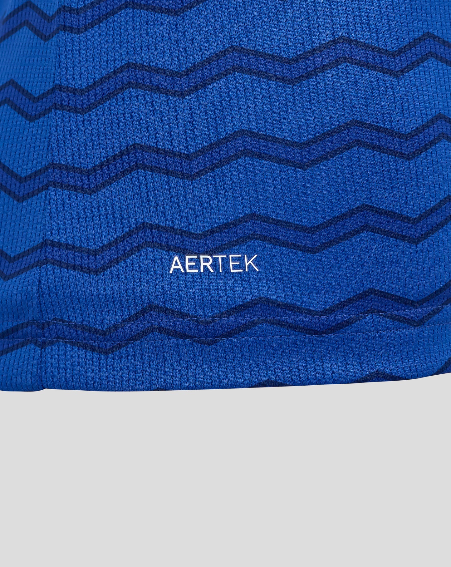Close up of blue Everton FC women's home shirt fabric showing a dark zigzag pattern and AerTek texture.