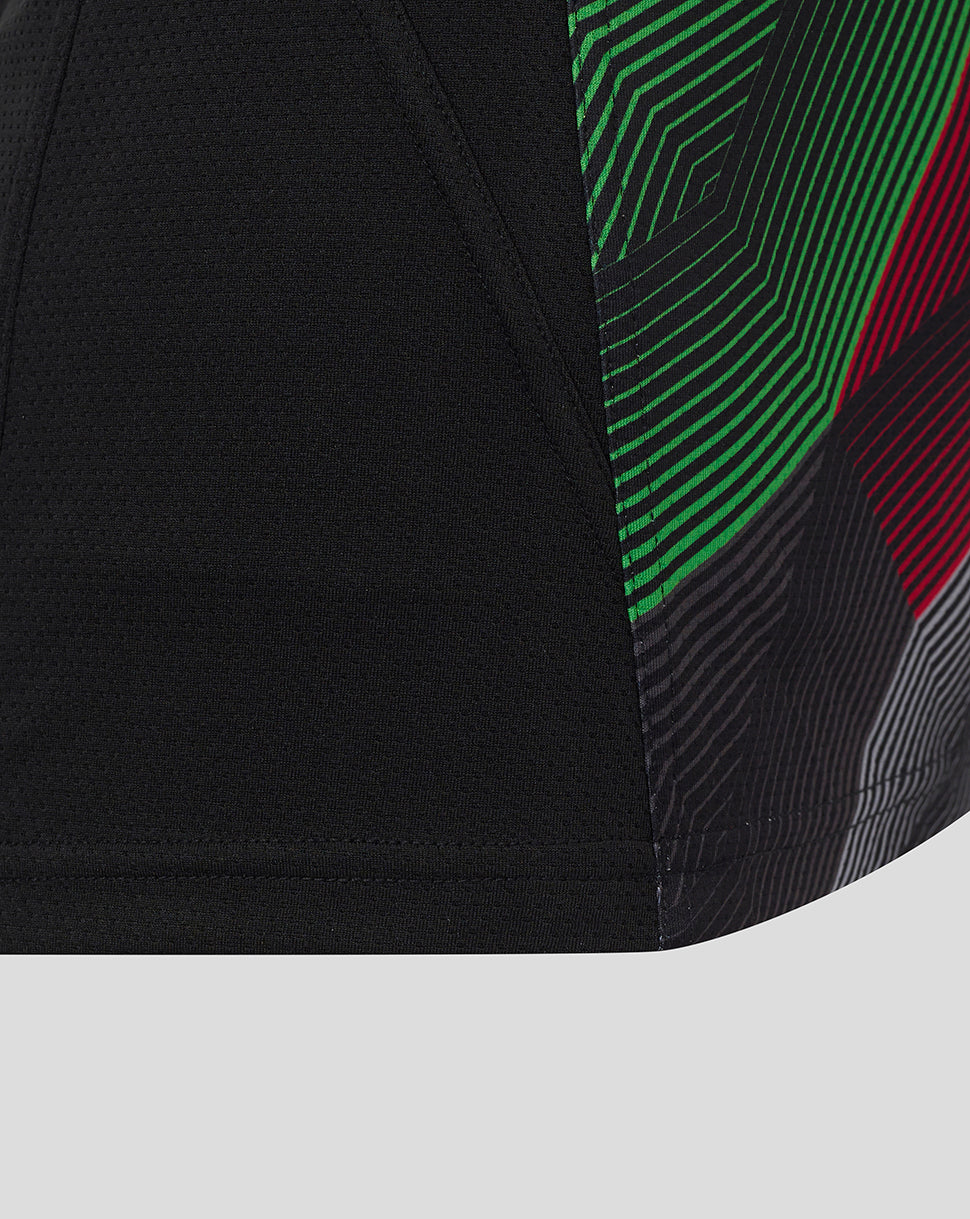 Close up of Harlequins sleeveless training tee showing black fabric with a green and red geometric side panel.
