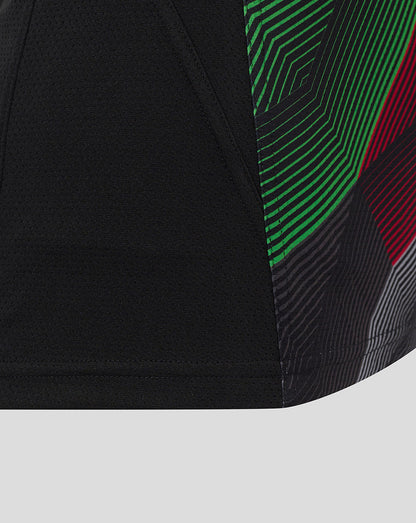 Close up of Harlequins sleeveless training tee showing black fabric with a green and red geometric side panel.