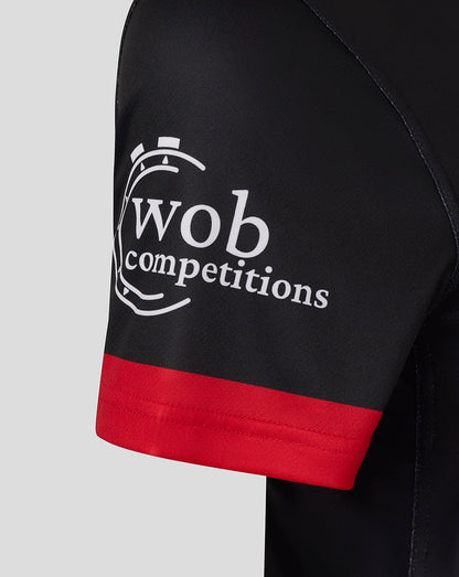 Sleeve close-up of black jersey with red cuff and white wob competitions logo