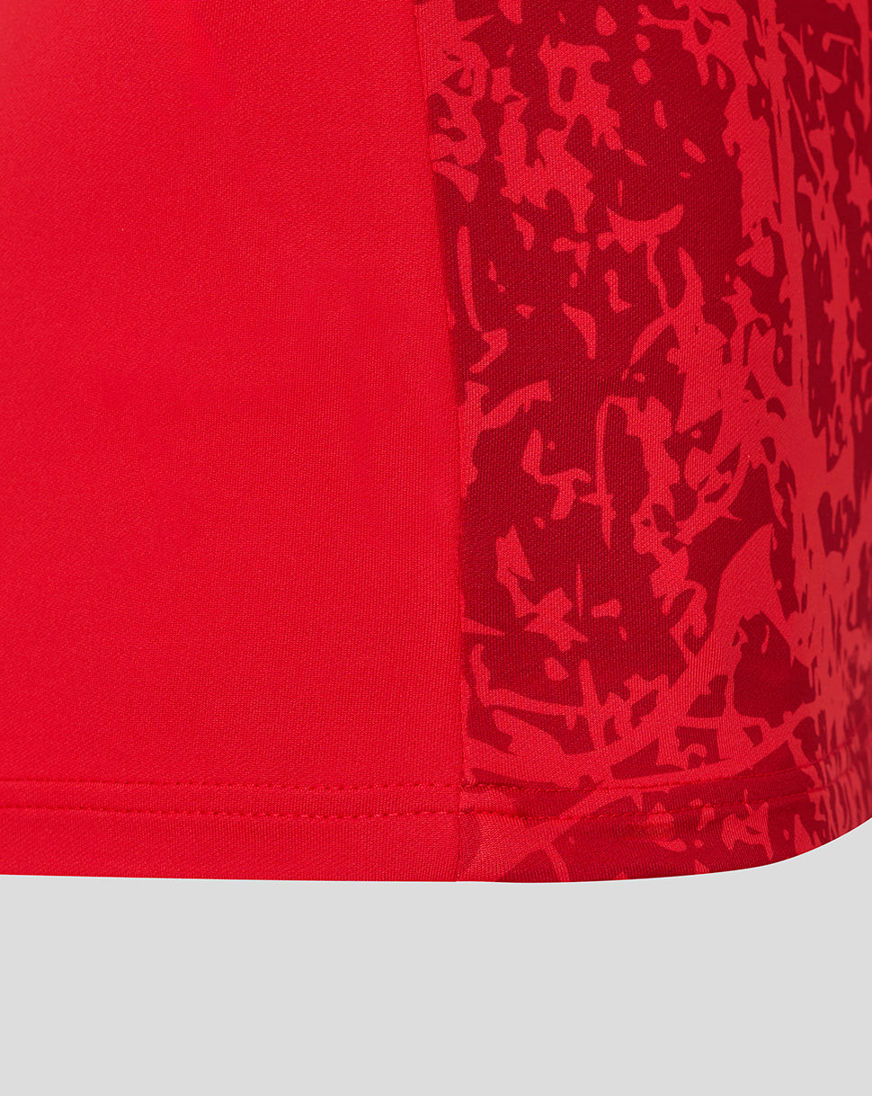 Close-up of the hem area on a red Saracens midlayer top, showing a darker abstract pattern