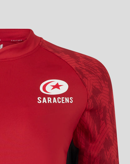 Shoulder close up of red Saracens training top featuring a geometric sleeve pattern and logos