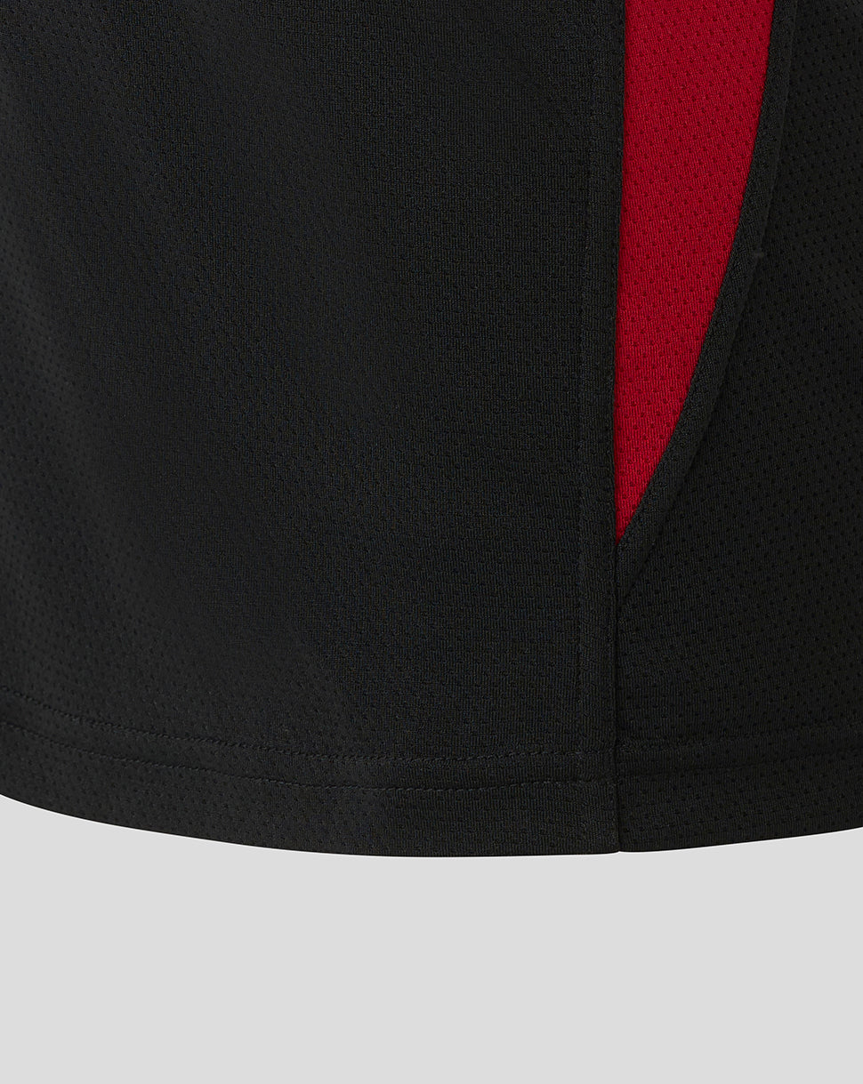 Close-up of black textured fabric from Saracens training tee with a red side panel.